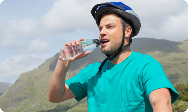 Man drinking water on bike ride wearing helmet