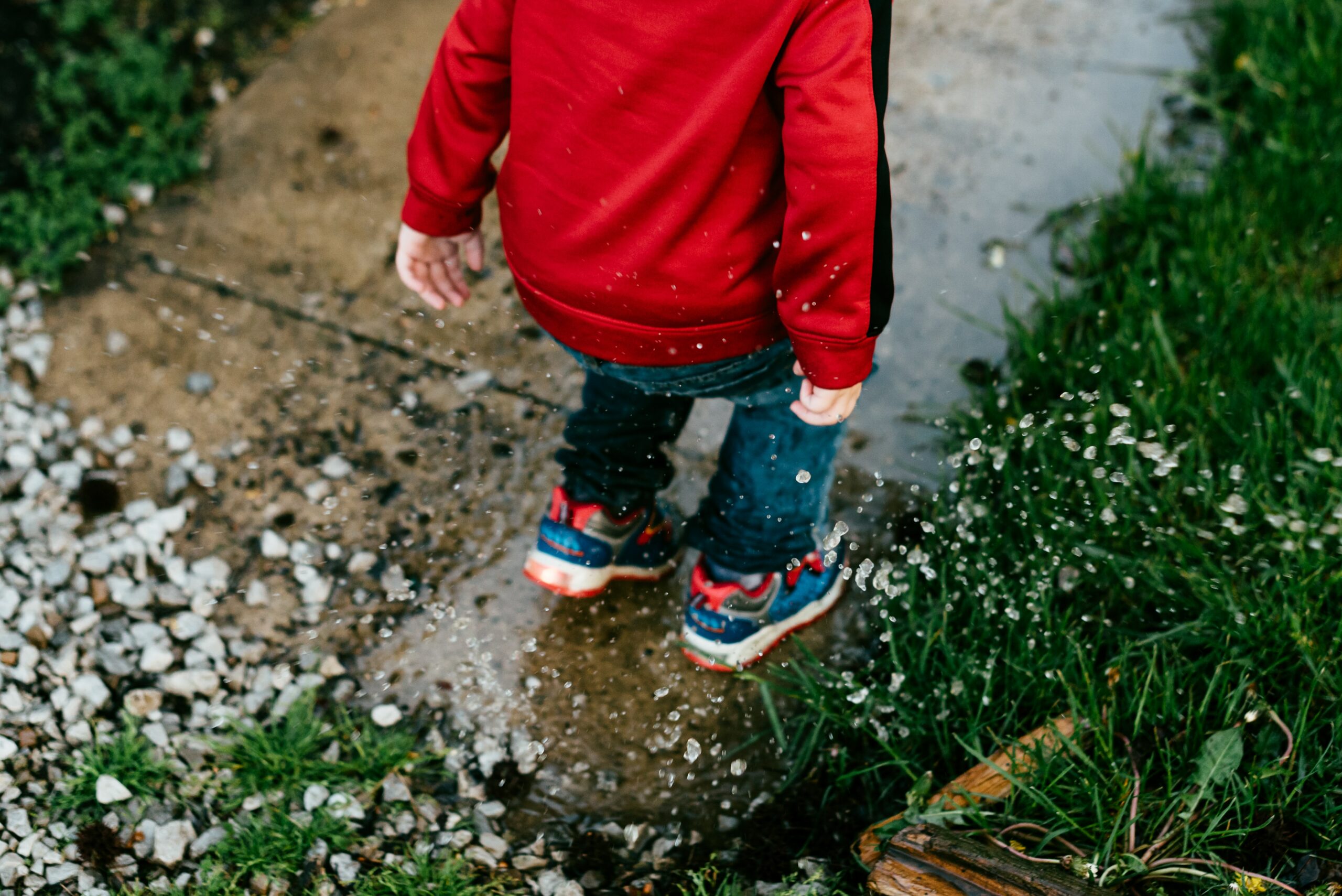 Child splashing in puddle